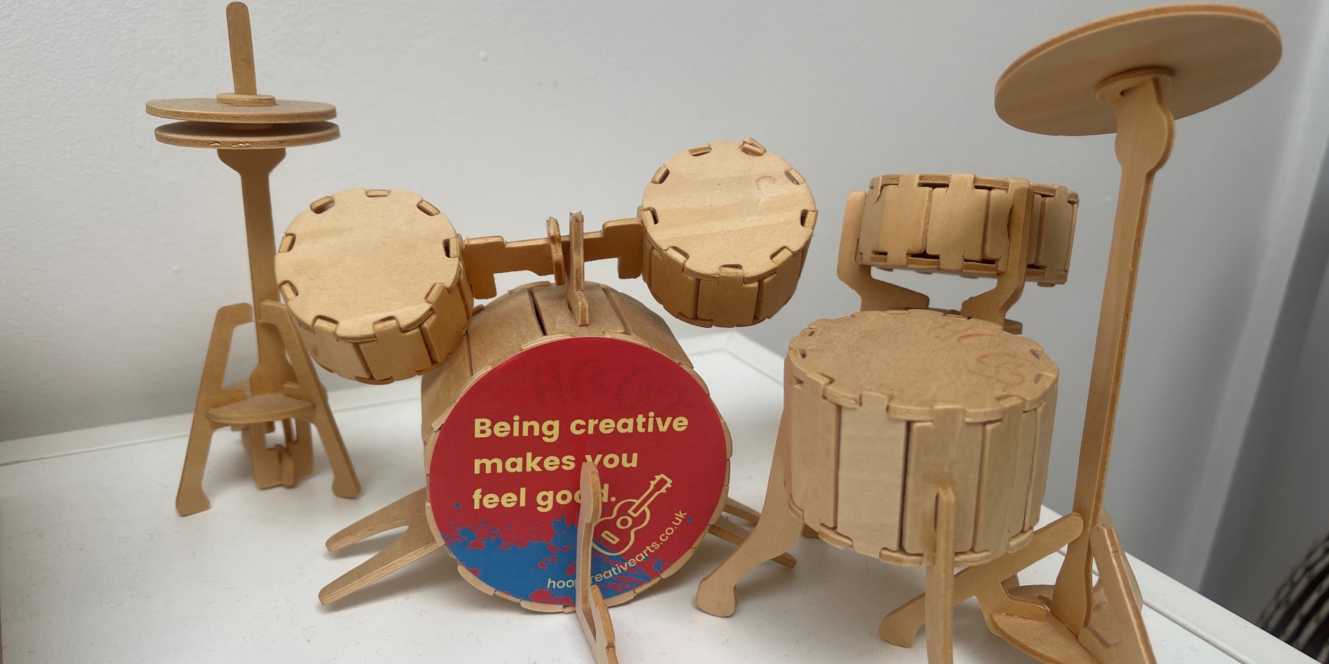 mini drum kit with a sticker that says being creative makes you feel good