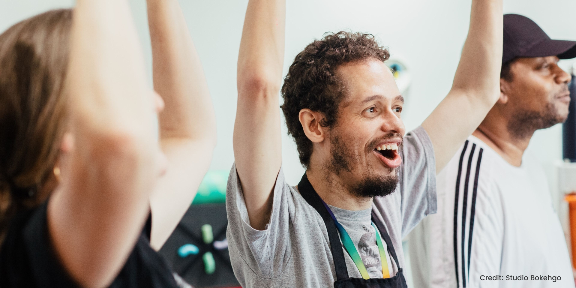 participants enjoying a session with their arms up and smiling