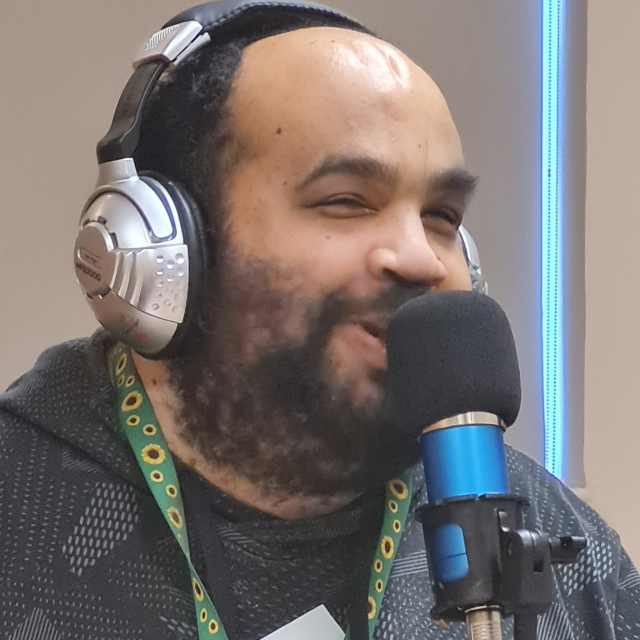 A man speaking into the mic recording a Podcast