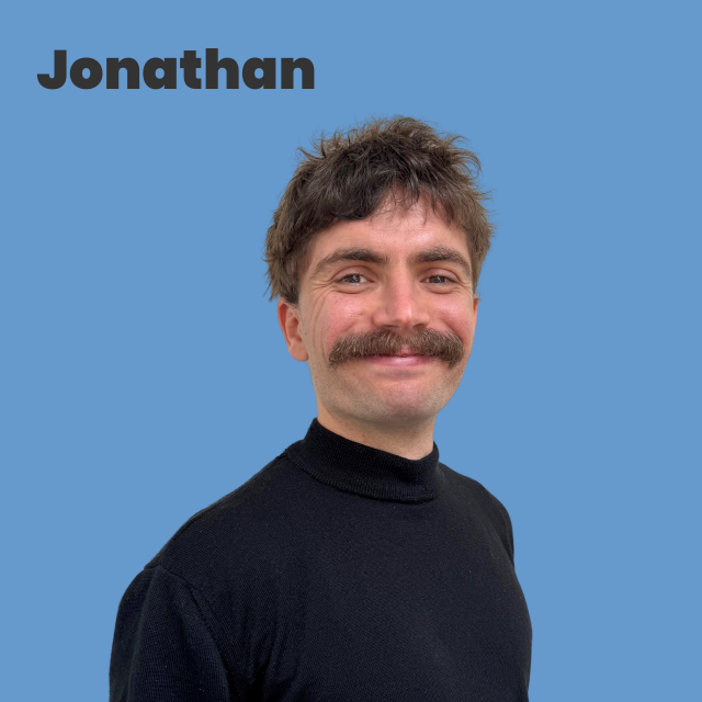 Picture of Jonathan, white man, short dark brown hair, moustache,  black top